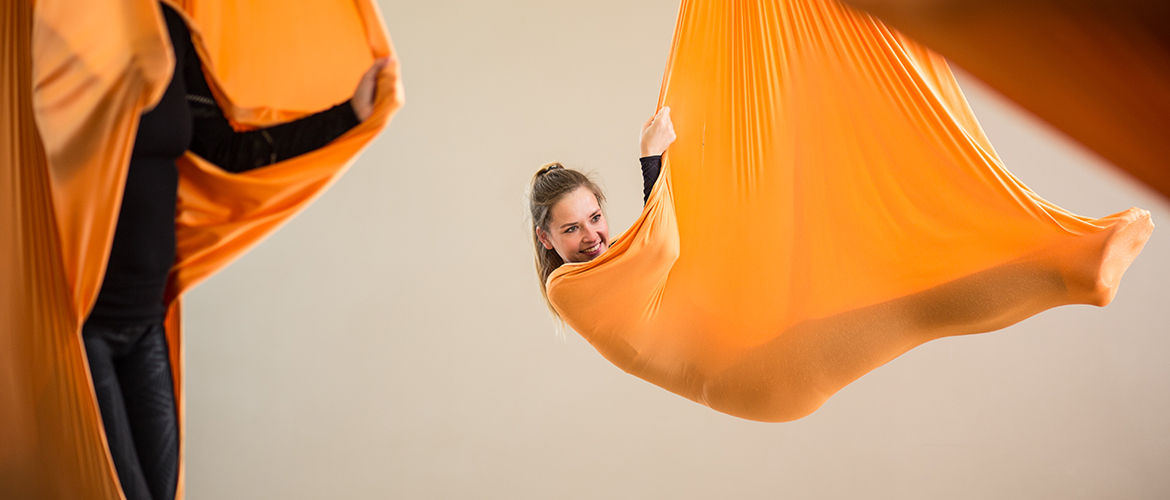 Dame liegt im Aerial Yoga Tuch