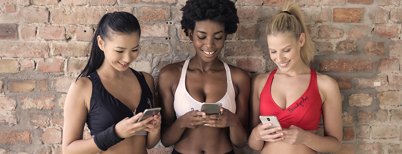 Three Beautiful Ladies in Sportswear with Smartphones